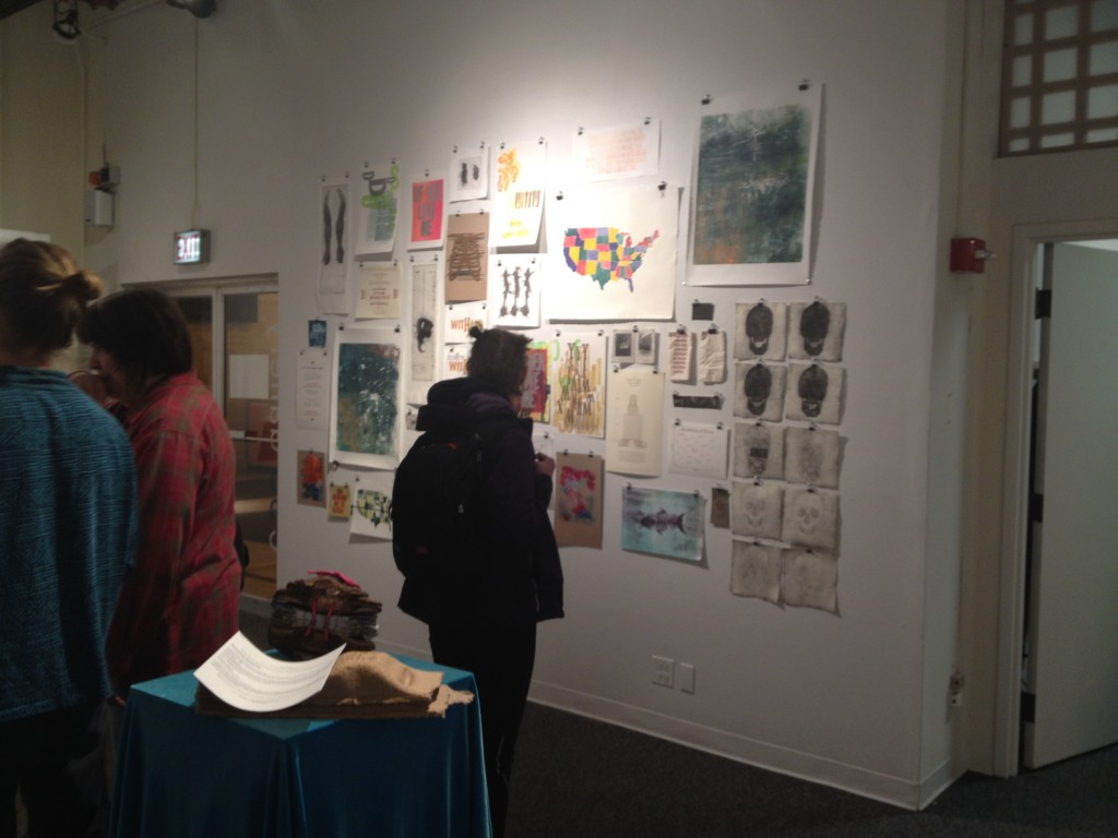 Visitors examine the wall of prints.